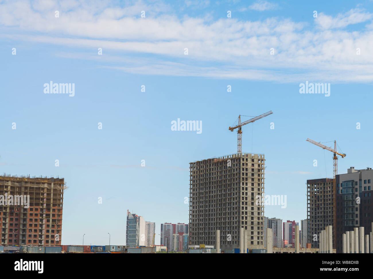 Gru e l'edificio in costruzione contro il cielo blu Foto Stock