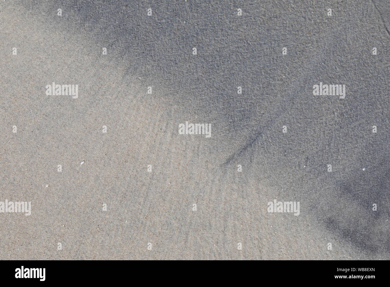 Bene, sabbia bagnata forme, buie e luminose strati, linea diagonale. Foto Stock