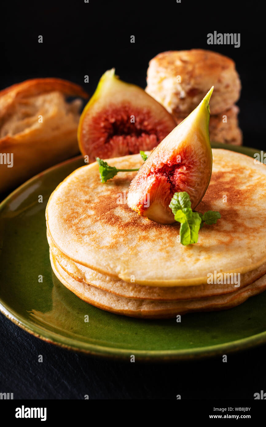 Concetto di cibo in casa frittelle organico stack con fig colazione su sfondo nero Foto Stock