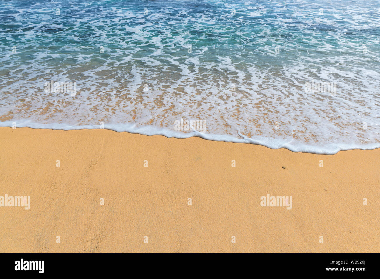 Soft oceano onde con la schiuma sulla spiaggia sabbiosa. Foto Stock