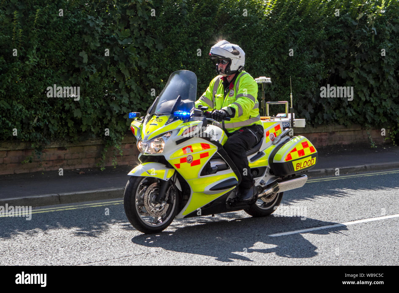 Biciclette del sangue volontario NHS che trasportano prodotti clinici, con luci blu lampeggianti di emergenza, Ormskirk, Lancashire, Regno Unito Foto Stock