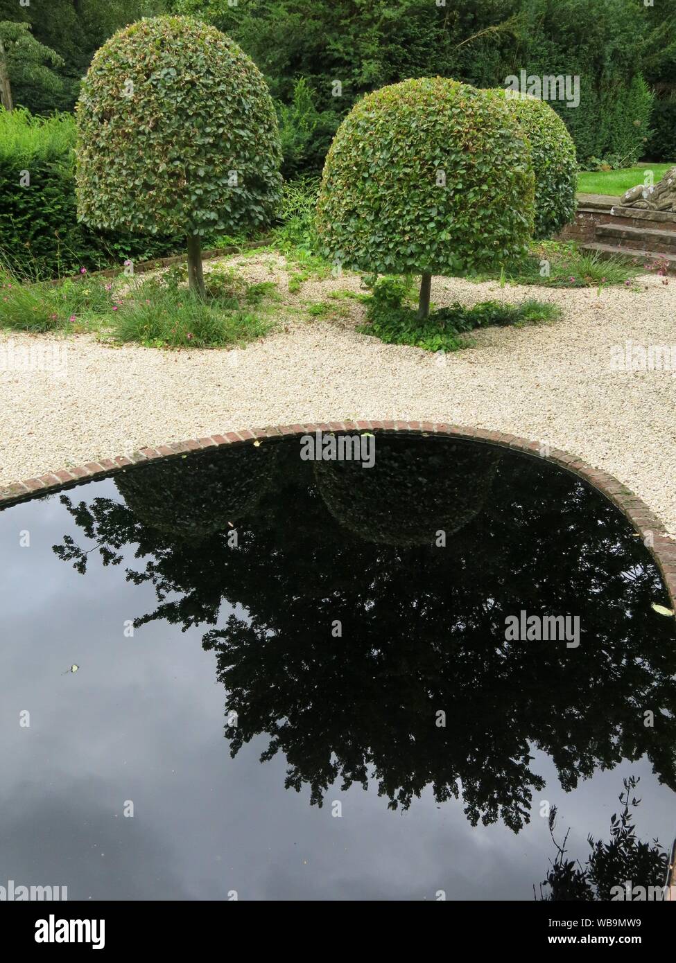 Il Giardino dei filosofi a Cottesbrooke include un inky black contemplazione piscina, dove dagli alberi circostanti sono riflessi nello specchio-come l'acqua. Foto Stock