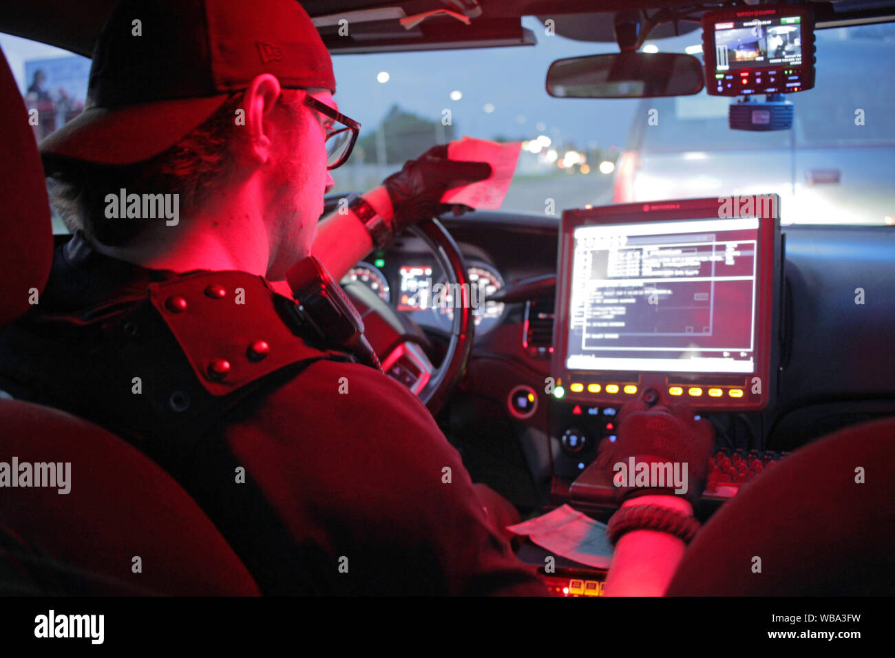 Detroit il dipartimento di polizia Special Ops offcier assegni a persone dettagli su un computer nella sua auto. Foto Stock