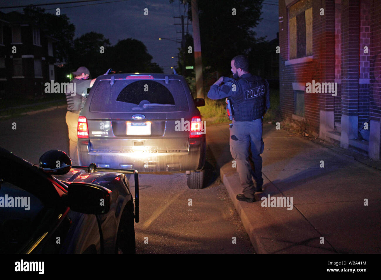 Gli ufficiali di polizia fermare un veicolo di notte a Detroit e a parlare con il conducente, Detroit, Michigan, Stati Uniti d'America Foto Stock