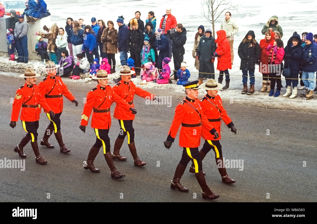 Un piccolo contingente di Royal Canadian polizia montata indossando il loro luminoso abito rosso uniformi marzo in una street parade per celebrare l'inizio dell'ancoraggio annuale Fur Rendezvous, il più antico e il più grande festival invernale in Alaska, Stati Uniti d'America. Conosciuto localmente come Fur Rondy, i dieci giorni di manifestazione sono state andando forte dal 1935 quando i minatori e cacciatori restituito alla città con oro e pellicce dalle loro fatiche invernali nel deserto. Il Campionato del Mondo di Sled Dog gare sono un punto culminante di questa rinomata Alaskan celebrazione. Foto Stock