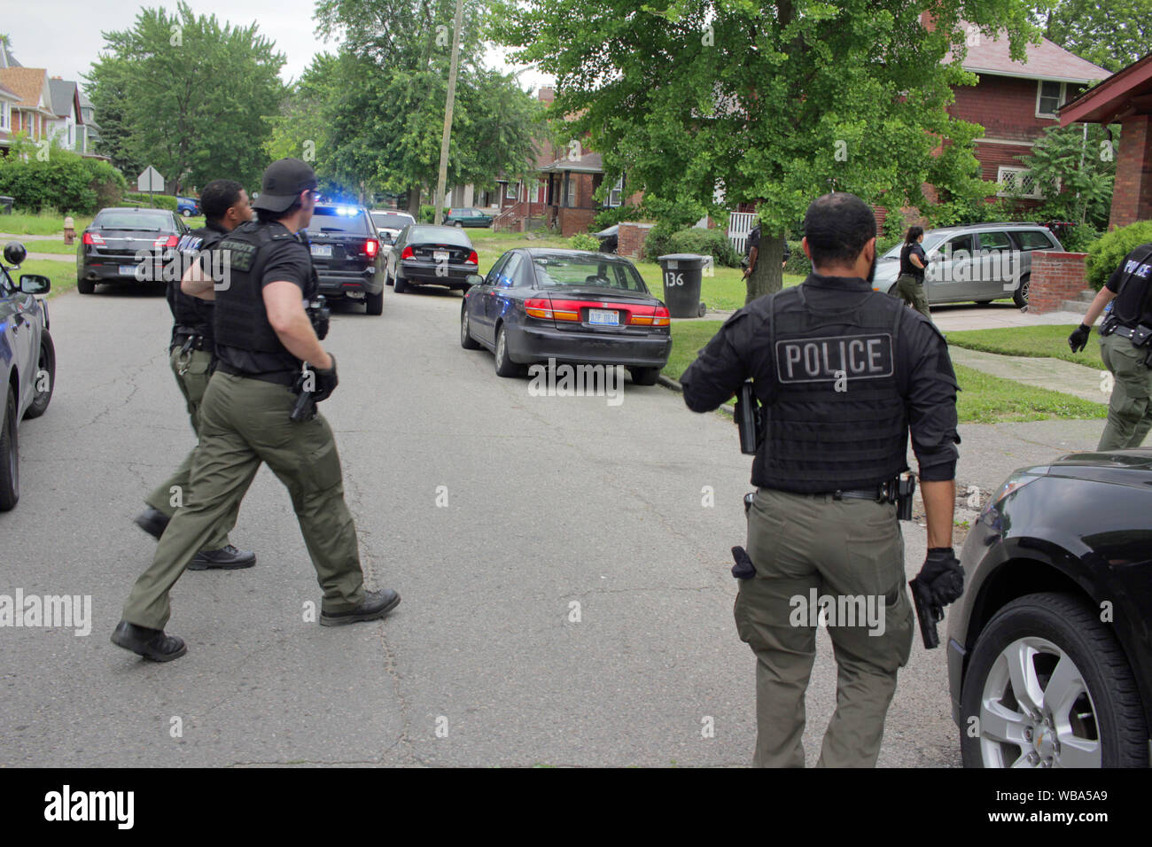 La Detroit del Dipartimento di Polizia di Ops speciale approccio ufficiali di una casa, come la ricerca di un voluto sospettare, Detroit, Michigan, Stati Uniti d'America Foto Stock
