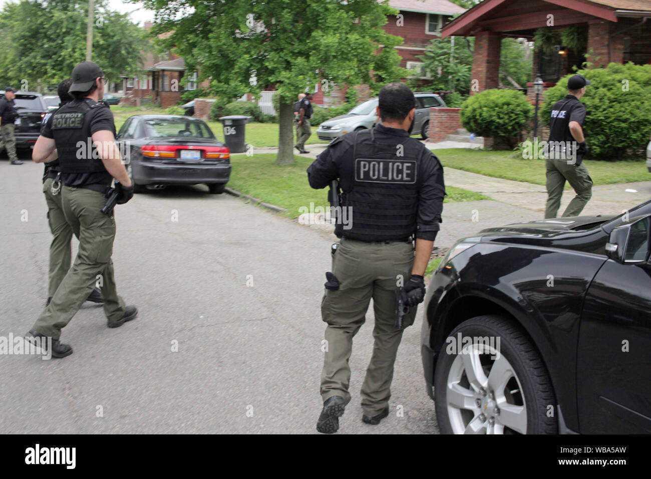 La Detroit del Dipartimento di Polizia di Ops speciale approccio ufficiali di una casa, come la ricerca di un voluto sospettare, Detroit, Michigan, Stati Uniti d'America Foto Stock