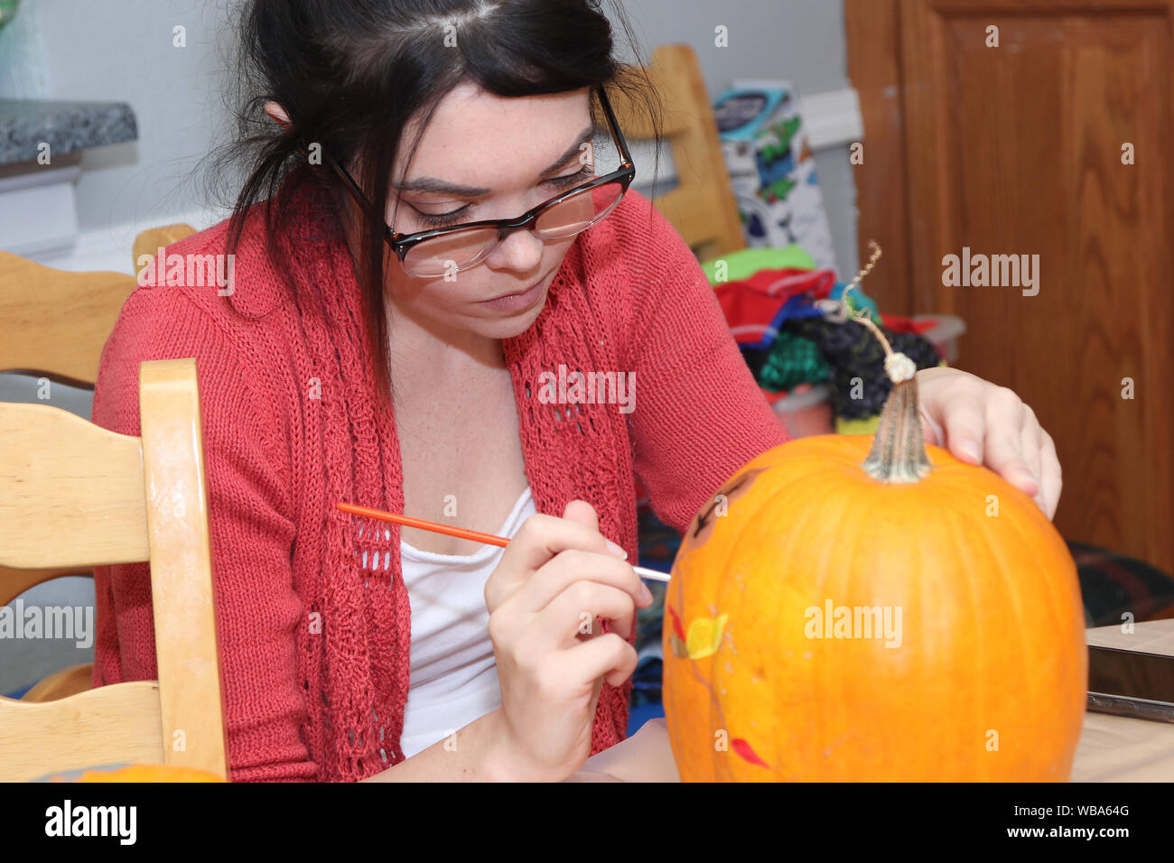 Insegnante che mostra gli studenti di pittura di zucca. Foto Stock