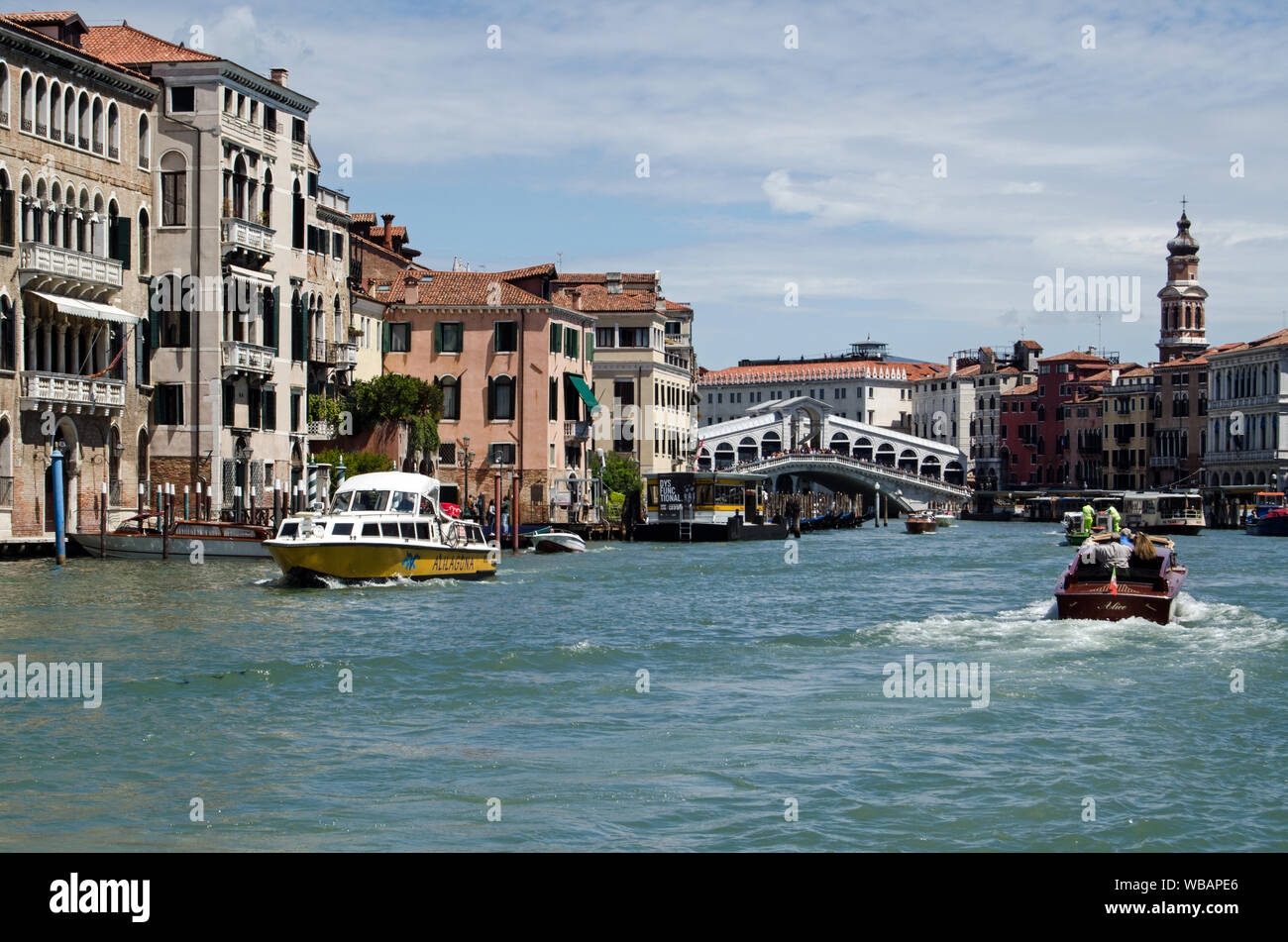 Venezia, Italia - 16 Maggio 2019: vista dalla riva Nord del Canal Grande di Venezia guardando verso il famoso Ponte di Rialto su una soleggiata giornata di primavera. Foto Stock