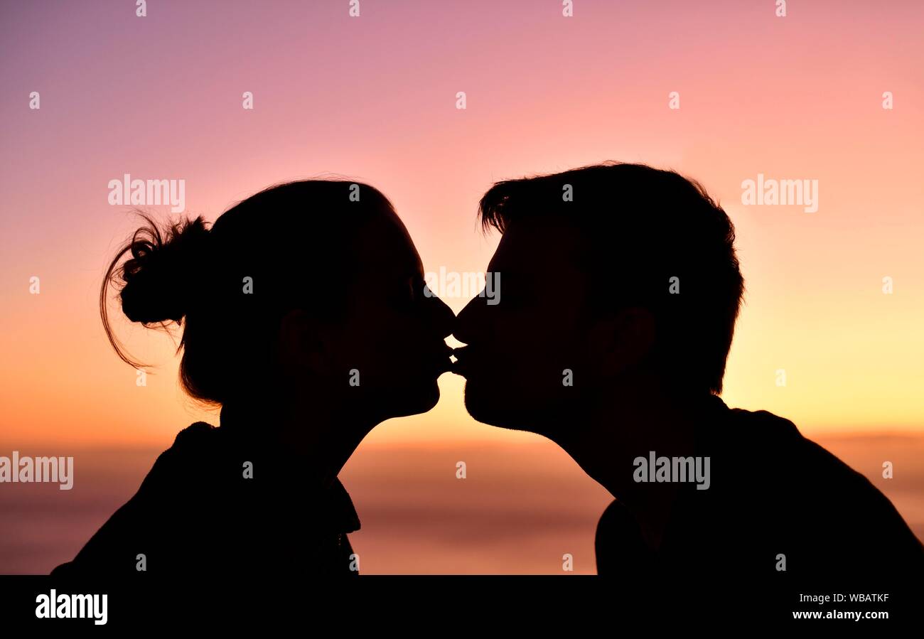Coppia giovane, amanti, baciate, silhouette, faccia a faccia, al tramonto, l'isola di Madeira, Portogallo Foto Stock