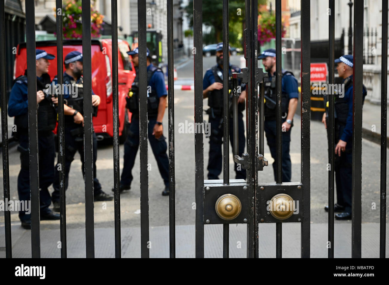 Poliziotti armati osservata attraverso i cancelli del 10 Downing Street, Downing Street, Whitehall, Londra. Regno Unito Foto Stock