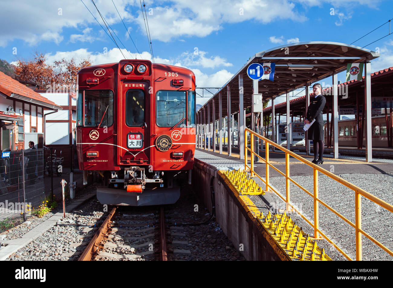 30 NOV 2018 Otsuki, Giappone - Rosso Treno Turistico Fuji Tozandensha con conduttore femmina alla stazione di Kawaguchiko piattaforma. Più famoso treno turistico su MO Foto Stock