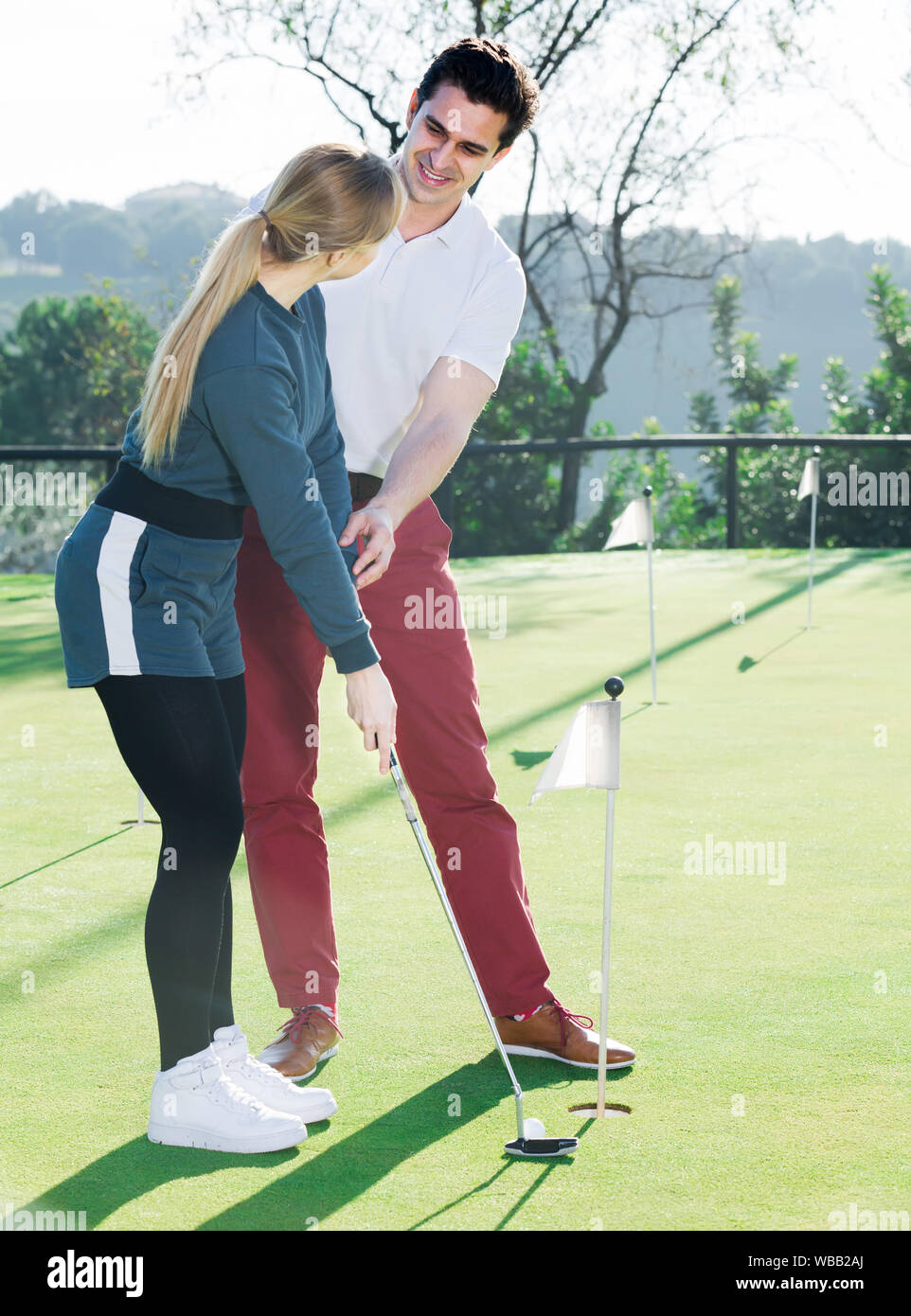 L'uomo insegna giovane donna golf di base hits Foto Stock