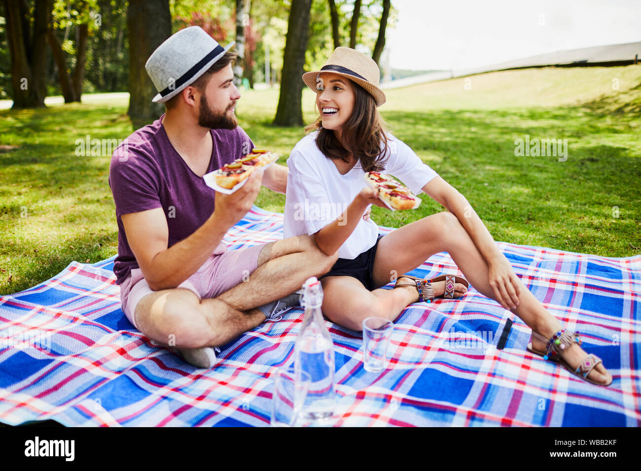 Coppia giovane su un picnic all'aperto mangiare insieme e ridere Foto Stock