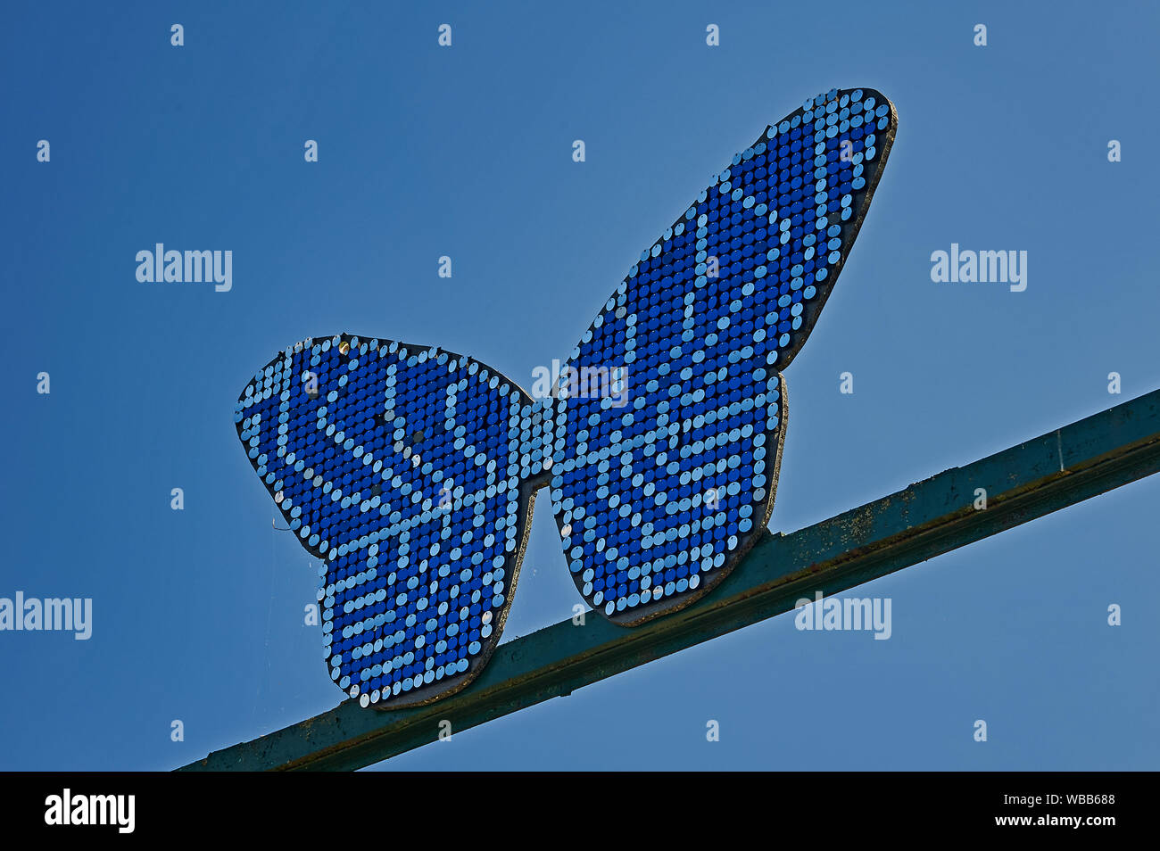 Abstract blue butterfly contro un cielo blu al di fuori dell'entrata alla Butterfly Farm in Stratford upon Avon, Warwickshire Foto Stock