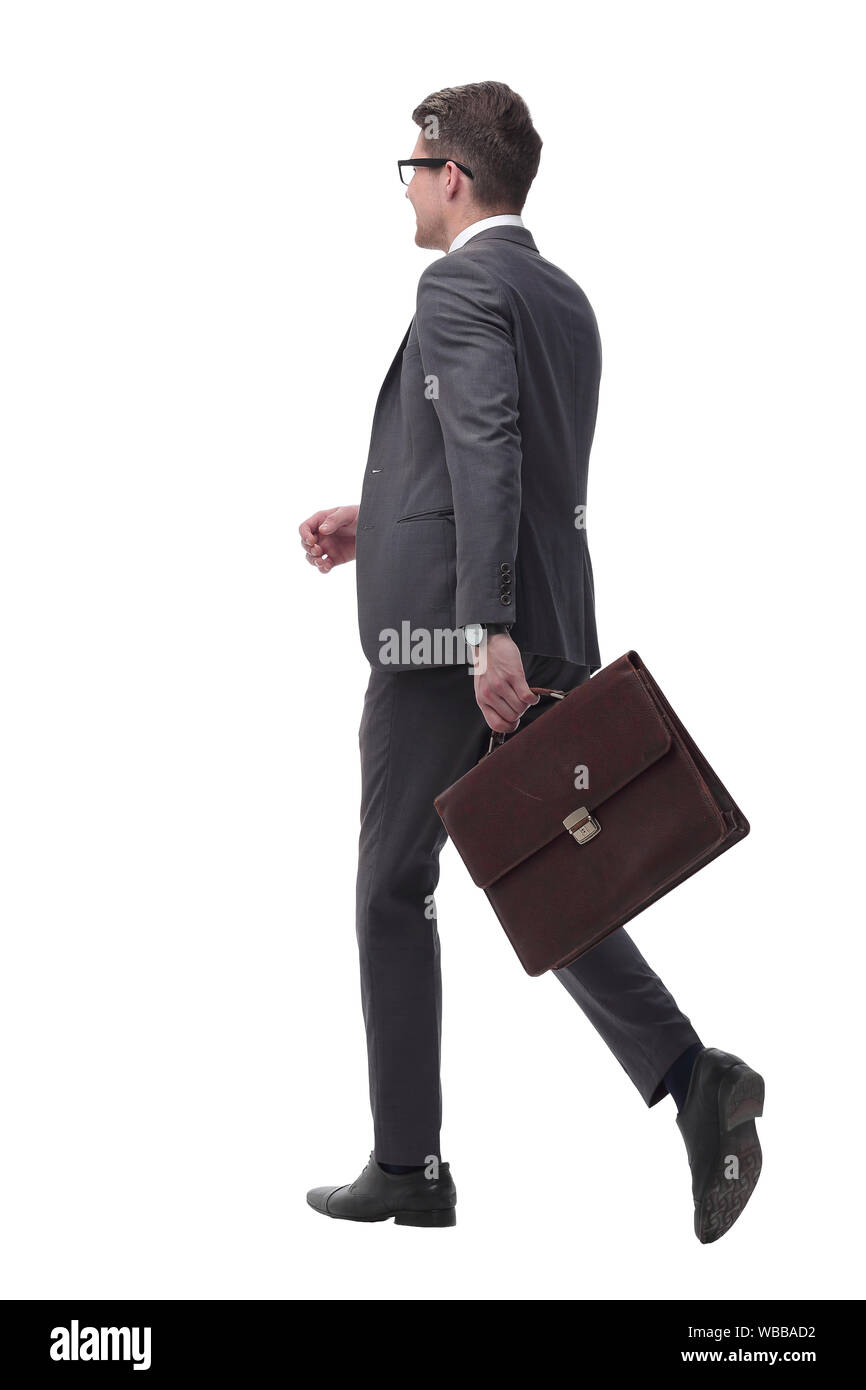 Vista laterale. fiducioso imprenditore con valigetta in pelle in avanti passo-passo Foto Stock
