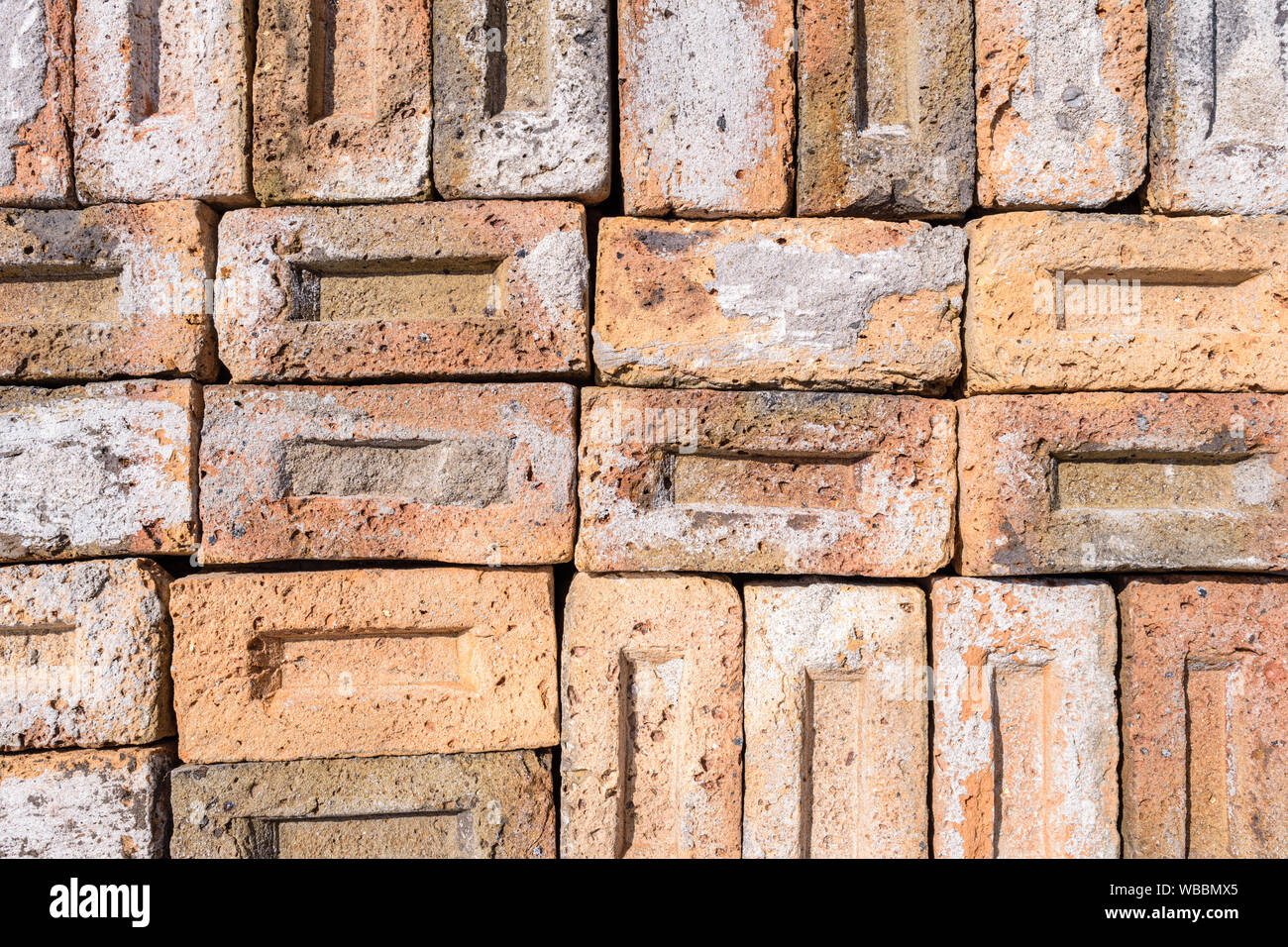 Una raccolta di materiali riciclati vecchi mattoni. I mattoni sono puliti da malta e calcestruzzo e pronto per il riutilizzo. Foto Stock