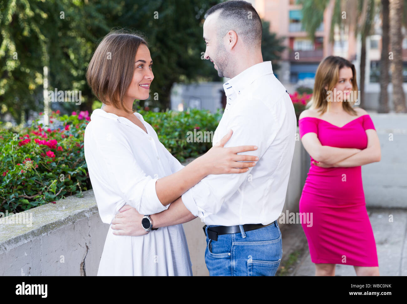 Lonely femmina è invidie alla coppia sorridente sulla strada. Foto Stock