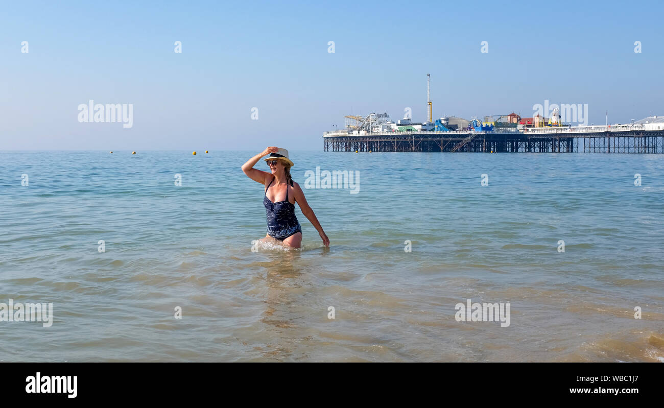 Brighton, Regno Unito. Il 26 agosto 2019. Questa signora gode di un inizio di mattina racchetta e tuffo in mare da Brighton Palace Pier su agosto lunedì festivo come le temperature sono attesi per raggiungere l'alta venti nuovamente nel sud-est . Stoviglie rosse le temperature sono state un record per un ferragosto insieme all aeroporto di Heathrow a Londra ad ovest . Credito: Simon Dack / Alamy Live News Foto Stock