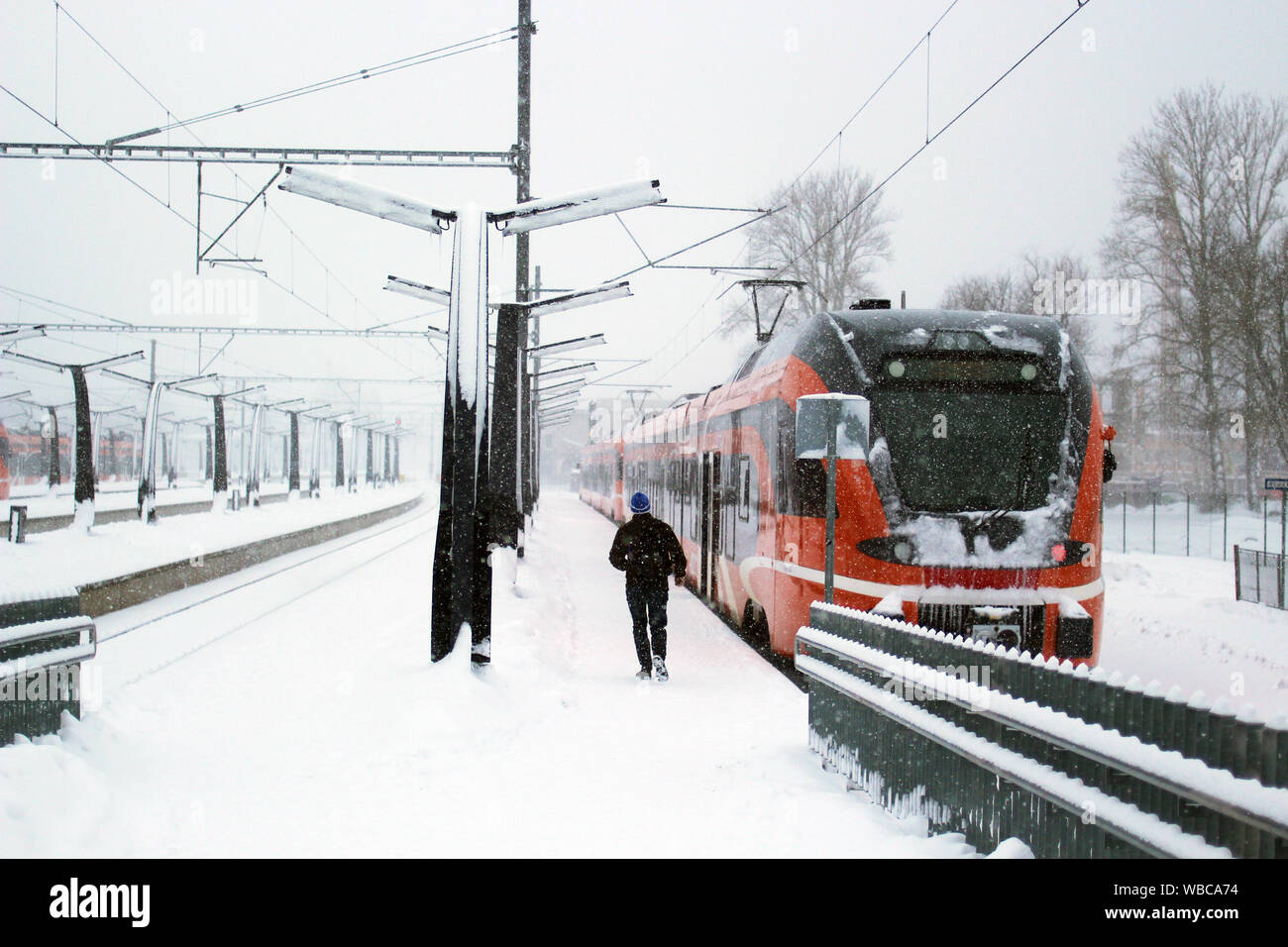Treno in stazione nevoso, la persona che esegue per treno Foto Stock