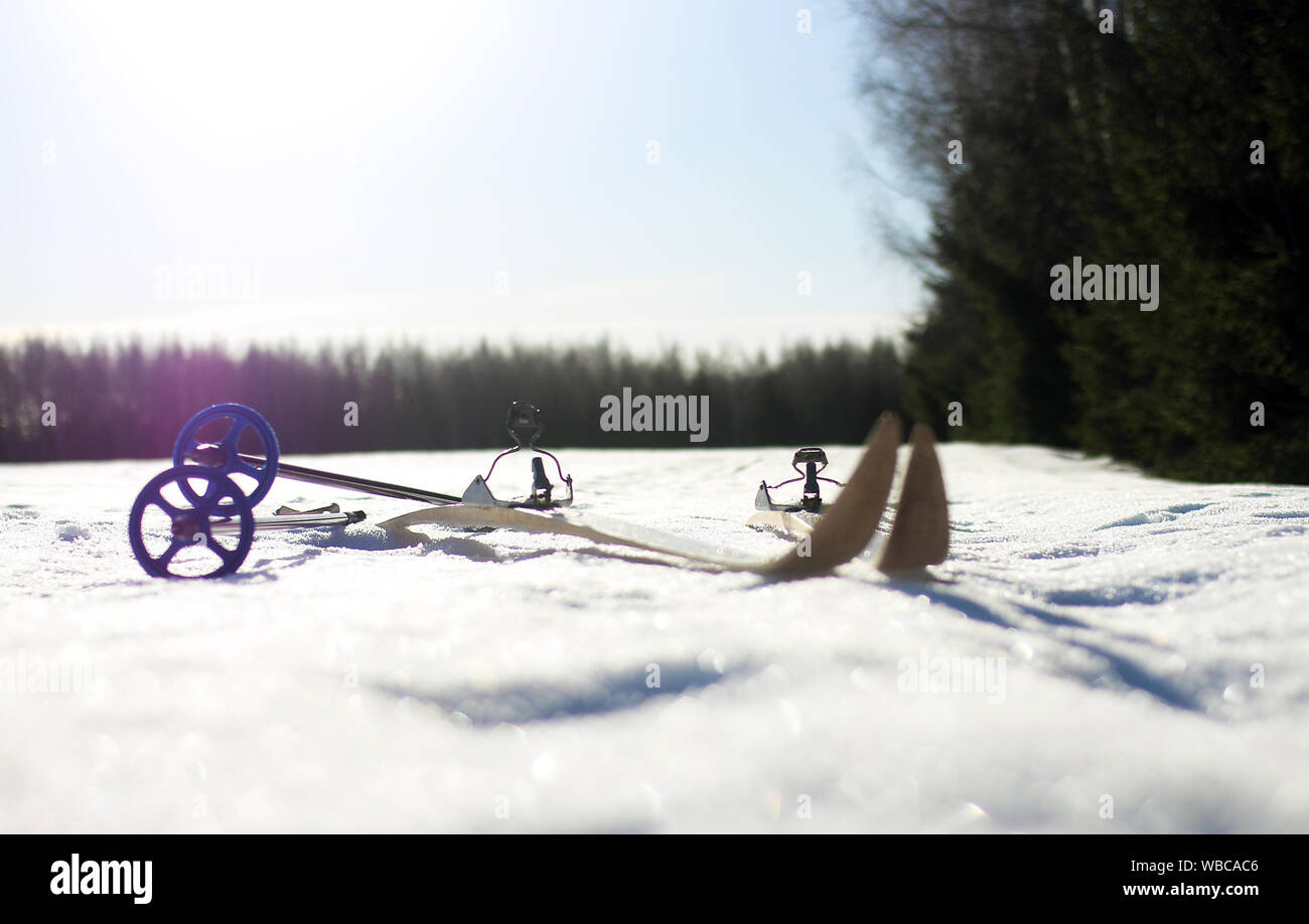 In legno antico sci di fondo sci e un vuoto snowy pista di sci con cielo blu chiaro Foto Stock