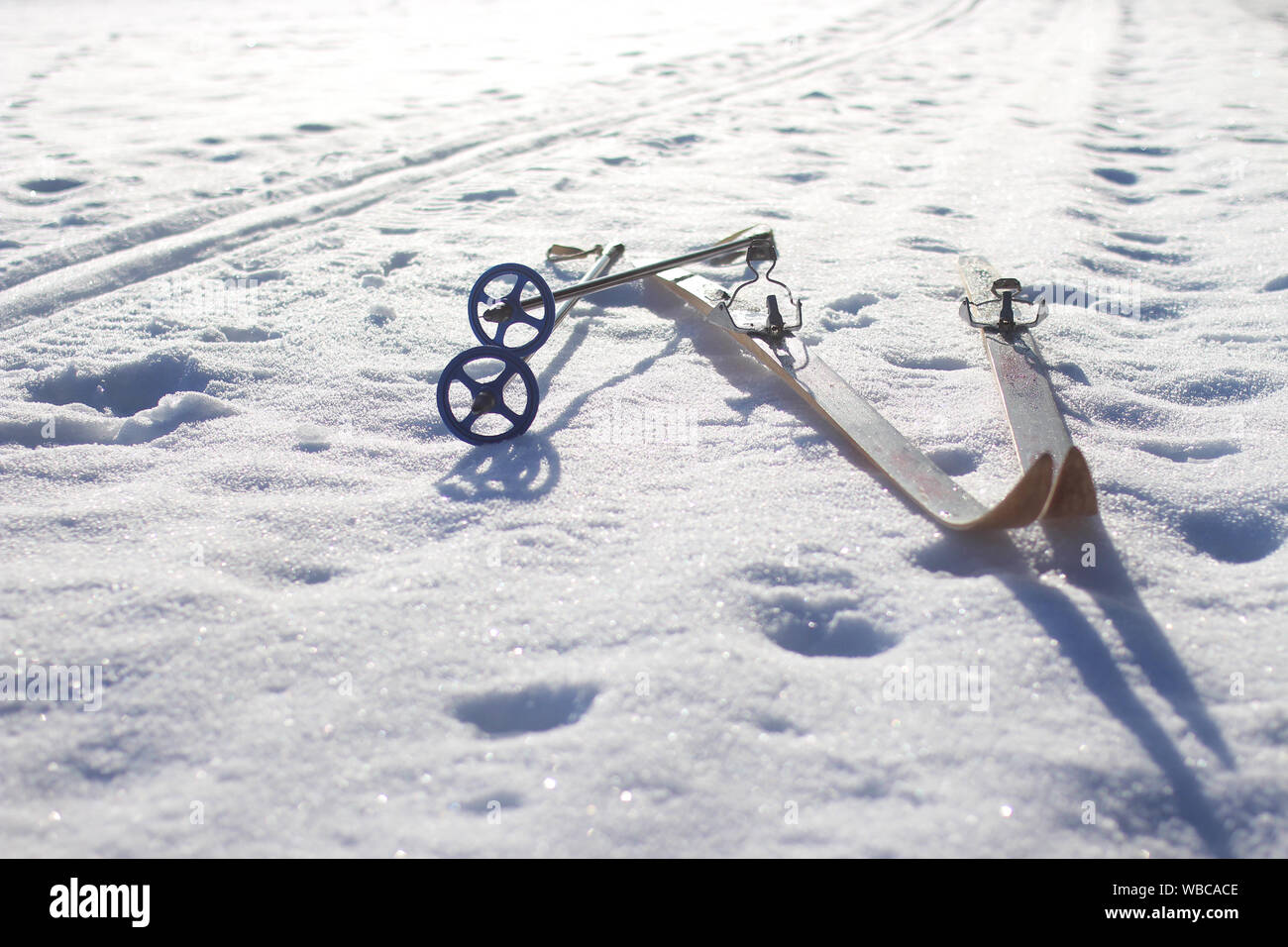 In legno antico sci di fondo sci e un vuoto snowy pista di sci con cielo blu chiaro Foto Stock