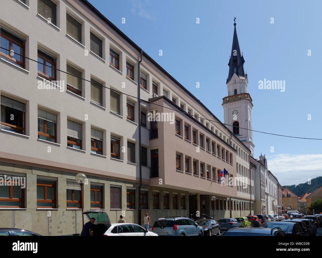 Slovenija, Celje. Presernova street con chiesa dell Assunzione di Maria (Cerkev Marijinega vnebovzetja) e la District Court. Foto Stock