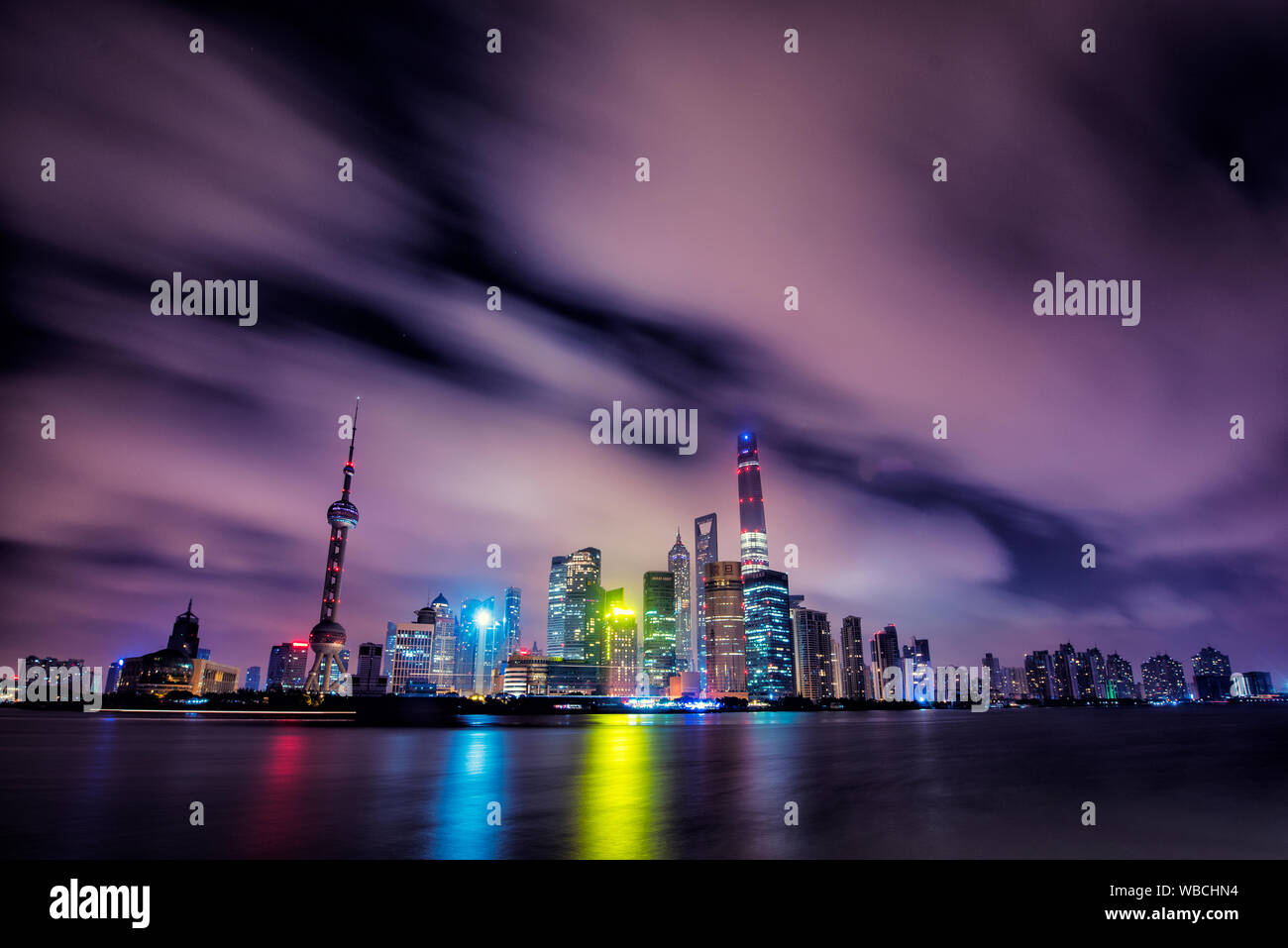 Skyline notturno della città di Shanghai con la sua riflessione sull'acqua, Cina Foto Stock