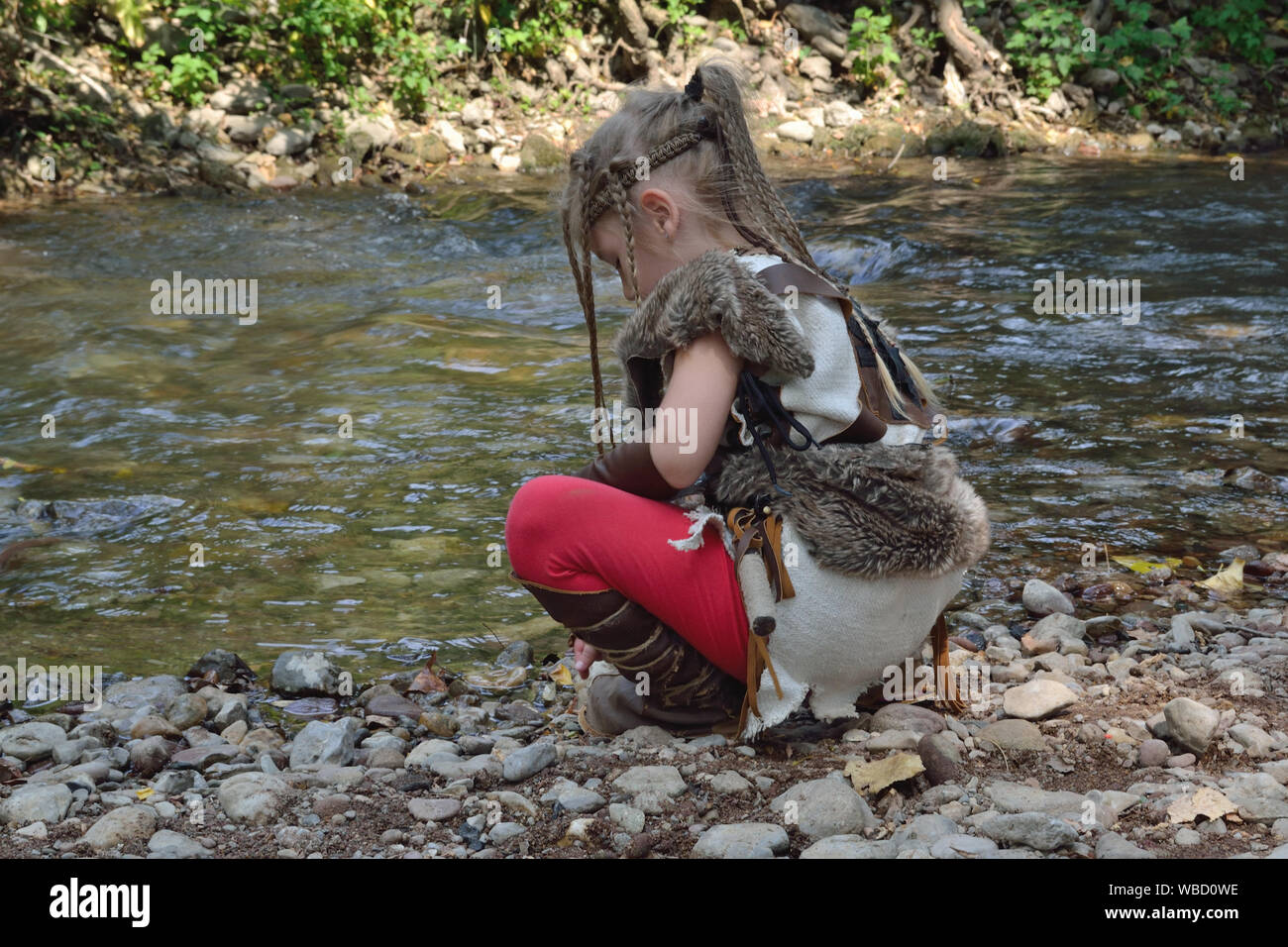 Viking bambino che gioca con rocce oltre ad un flusso.Il terzo giorno della international festival medievale 'appena fuori' in Manasija,Serbia,l'Europa 25 Ago 2019 Foto Stock