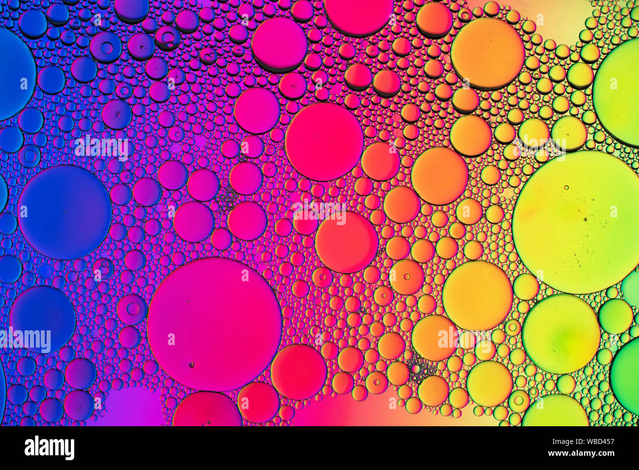 Motivi a bolle multicolore formati da olio che galleggia sull'acqua Foto Stock