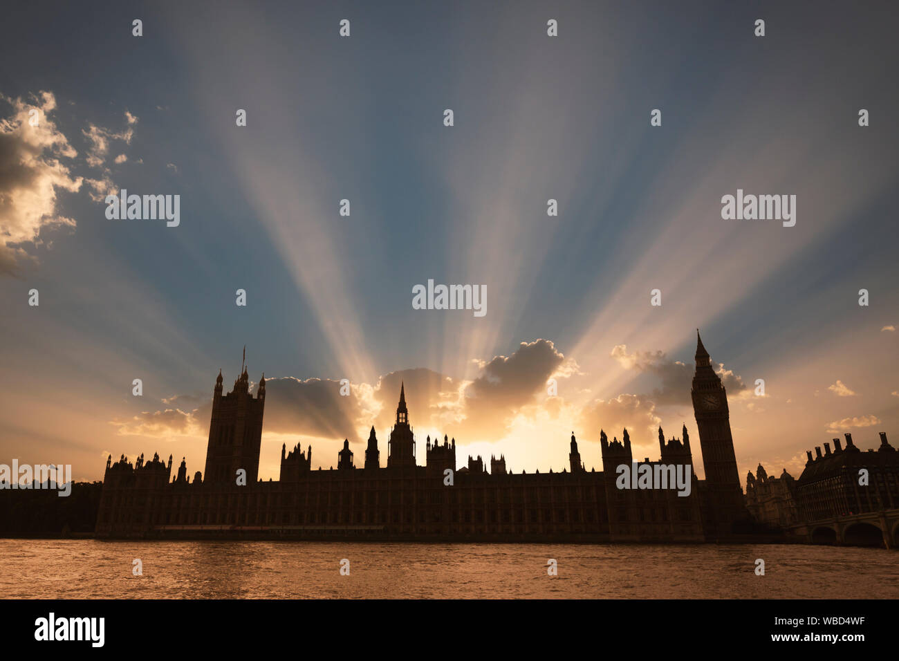Drammatica raggi di sole dietro il Palazzo di Westminster come il sole tramonta a Londra. Foto Stock