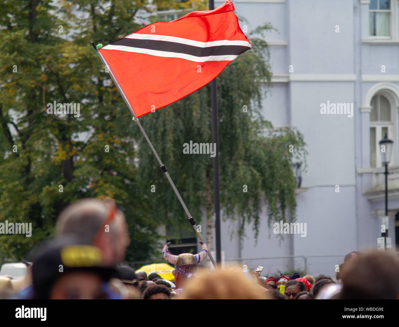 Una Bandiera di Trinidad e Tobago battenti, durante la celebrazione.I principali eventi del carnevale di Notting Hill 2019 ha preso il via con oltre un milione di festaioli di colpire le strade di West London, tra i galleggianti, masqueraders, nastri di acciaio, e sistemi audio. Foto Stock