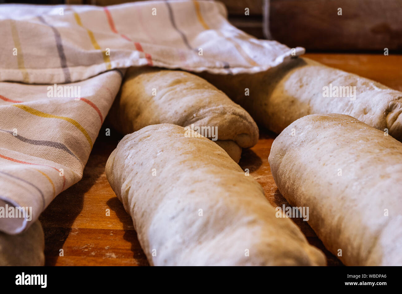 Rotoli di pasta lievitata in attesa di essere formati in baguette francese per la cottura Foto Stock