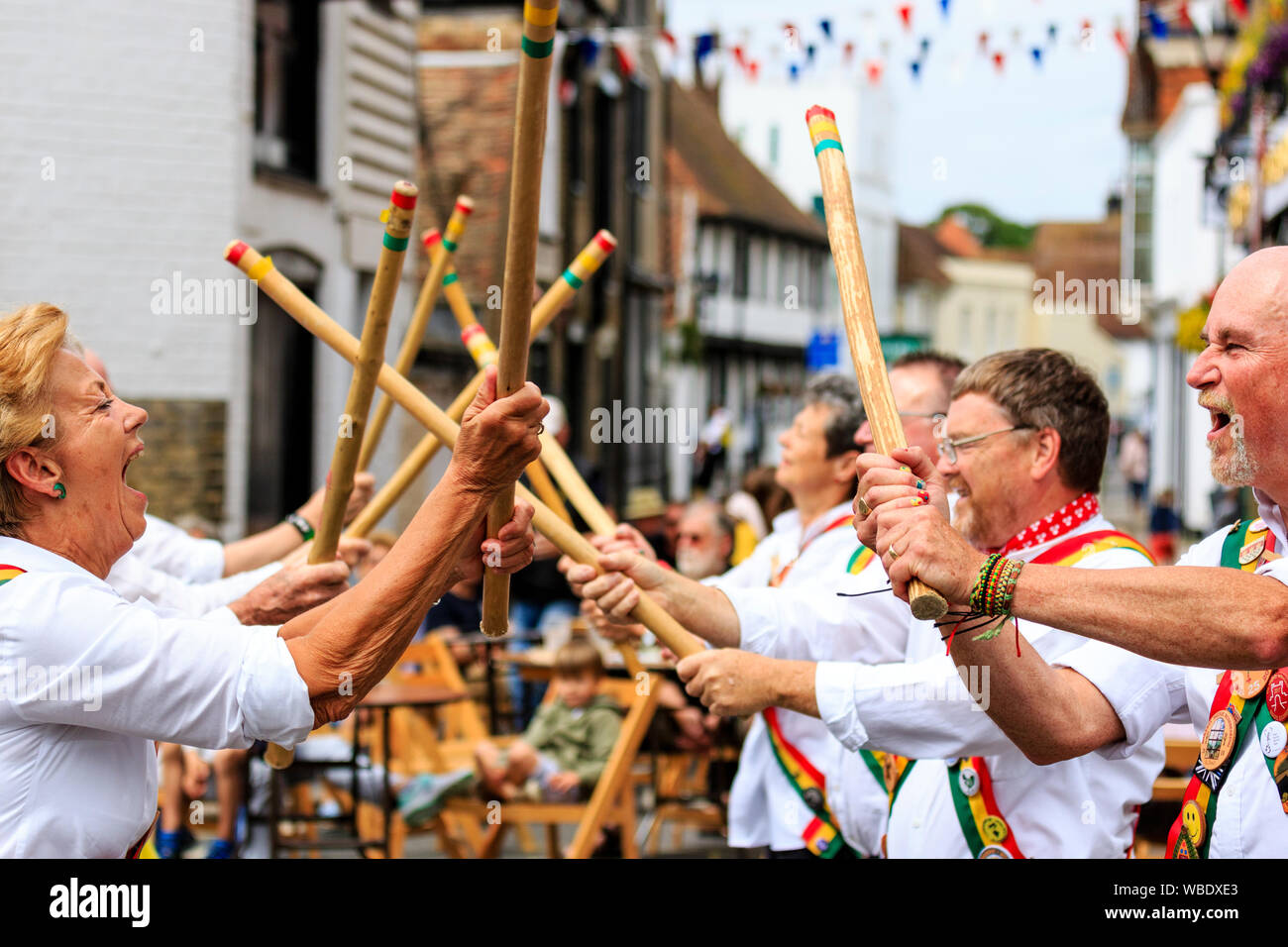 Sandwich e folk festival Ale. Inglese tradizionale ballerini folk, Gallo rampante Morris misti di contenimento laterale e colpendo bastoni di legno in strada. Foto Stock