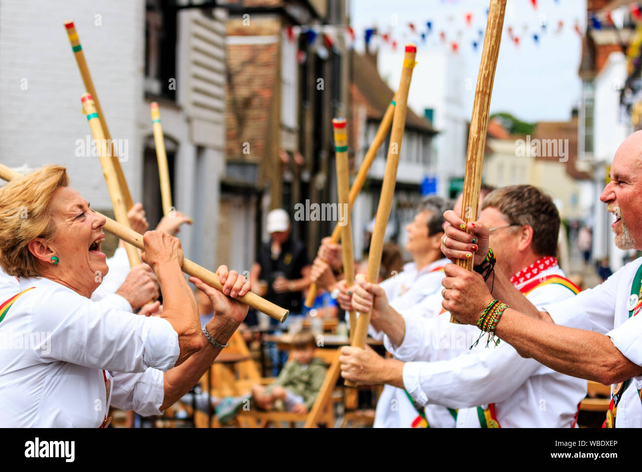 Sandwich e folk festival Ale. Inglese tradizionale ballerini folk, Gallo rampante Morris misti di contenimento laterale e colpendo bastoni di legno in strada. Foto Stock