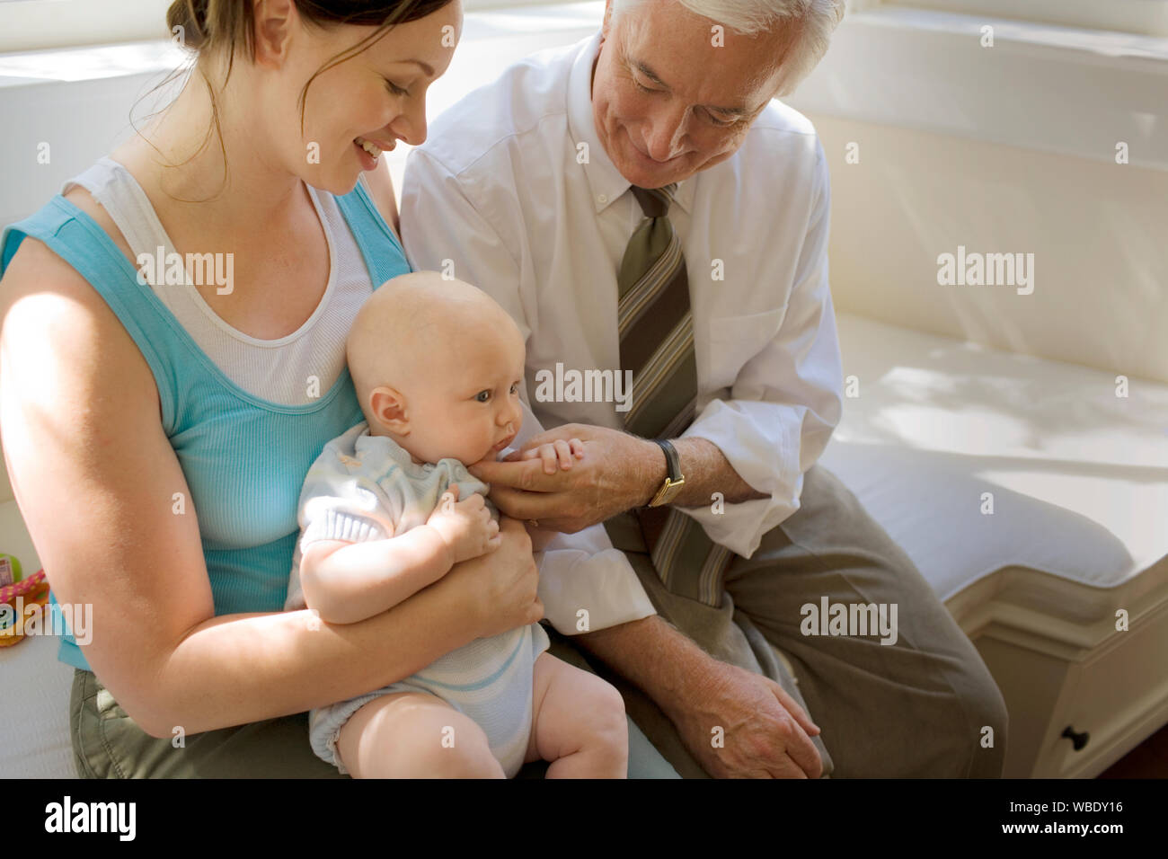 Senior uomo seduto con sua figlia adulta e nipote. Foto Stock