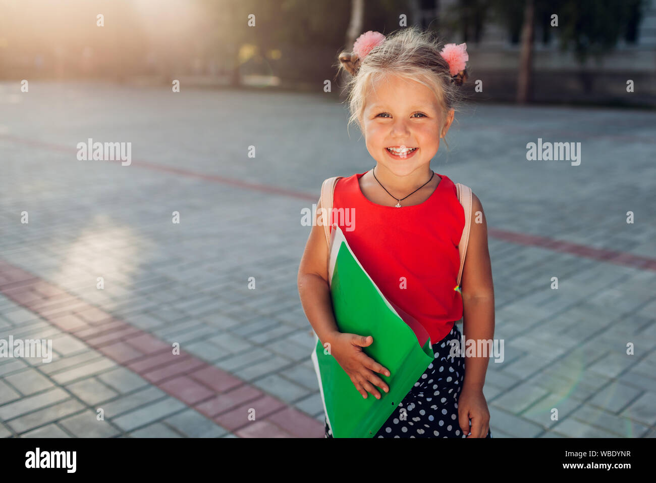 Bambino pronto per la scuola primaria. Felice pupillo bambina indossa uno zaino e file di contenimento. Il concetto di istruzione. Si torna a scuola Foto Stock