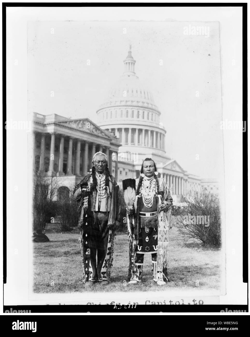 Frank Seelatse e Chief Jimmy Noè Saluskin; inglese: Native American chiefs Frank Seelatse e Chief Jimmy Noè Saluskin della tribù Yakama poste, ritratto a figura intera, in piedi, rivolto verso la parte anteriore, con gli Stati Uniti Capitol dietro di loro. Foto Stock