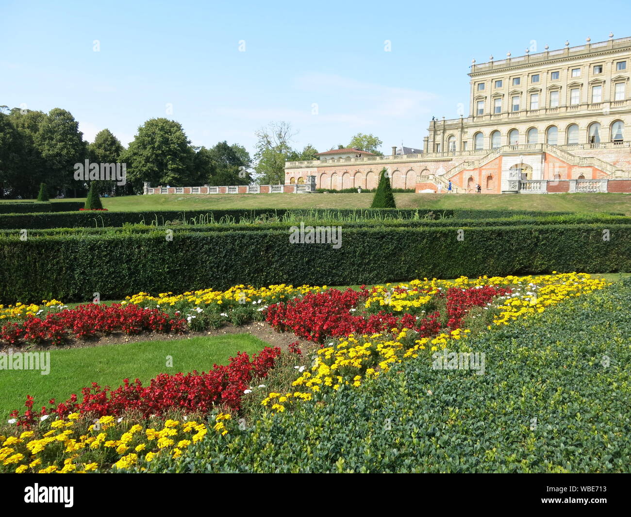 La sontuosa villa a Cliveden costruito nel 1666, con il colorato formale schema impianto nel parterre in rosso e in giallo per l'estate 2019 Foto Stock