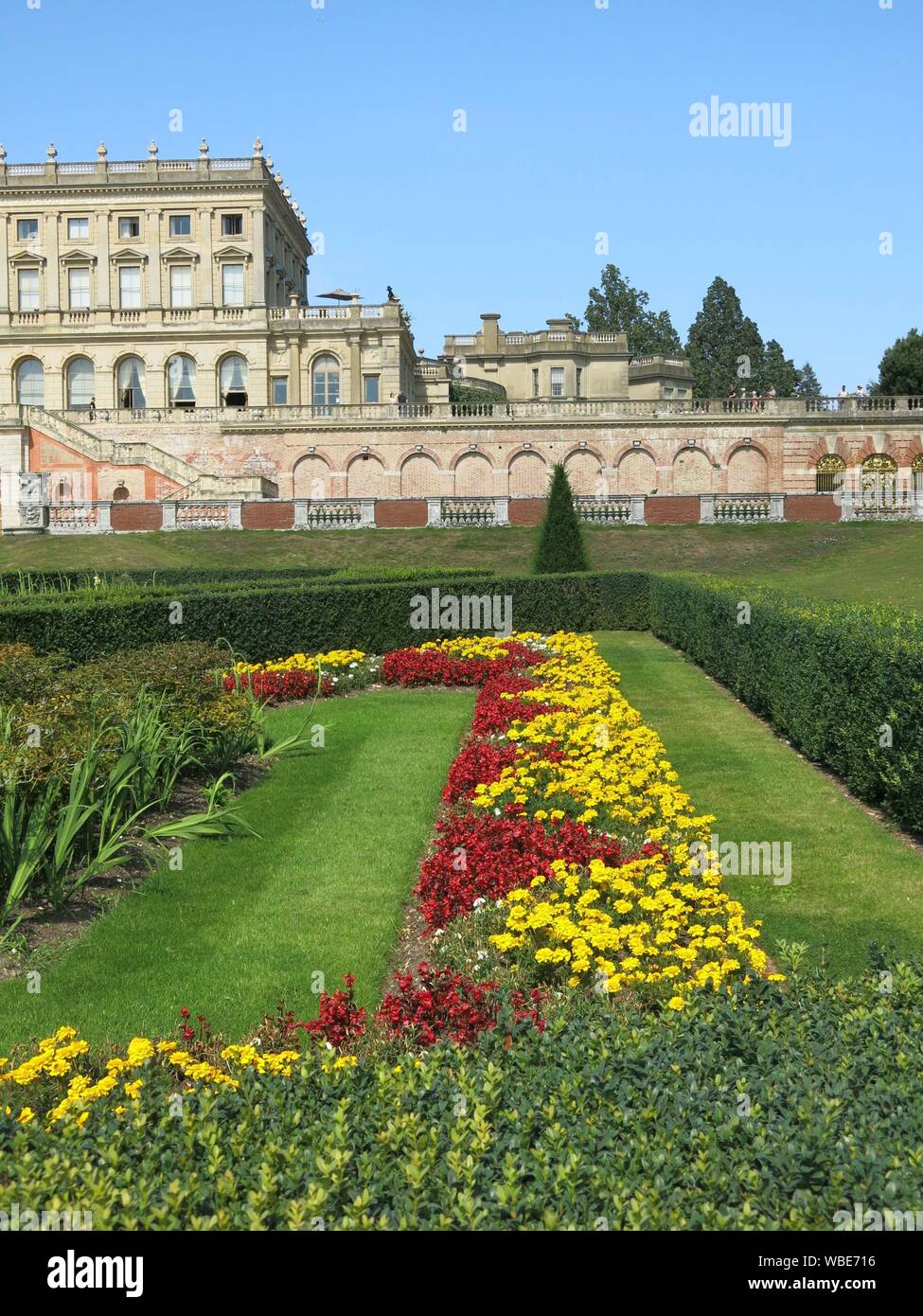 La sontuosa villa a Cliveden costruito nel 1666, con il colorato formale schema impianto nel parterre in rosso e in giallo per l'estate 2019 Foto Stock
