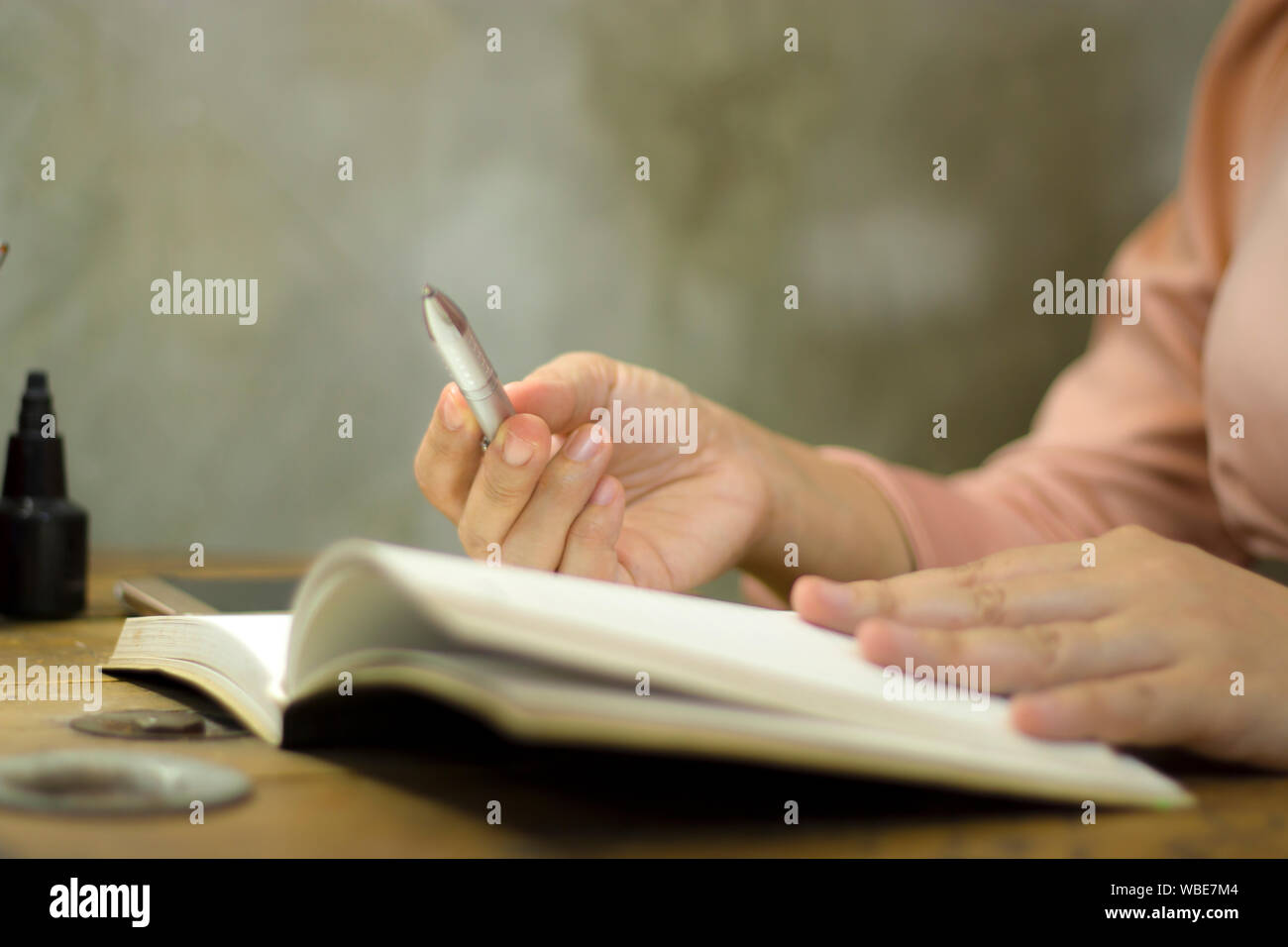 Giovane donna di affari di lavorare con una penna in ufficio, ella stare le ore di lavoro straordinario. Immagine ad alta risoluzione gallery. Foto Stock