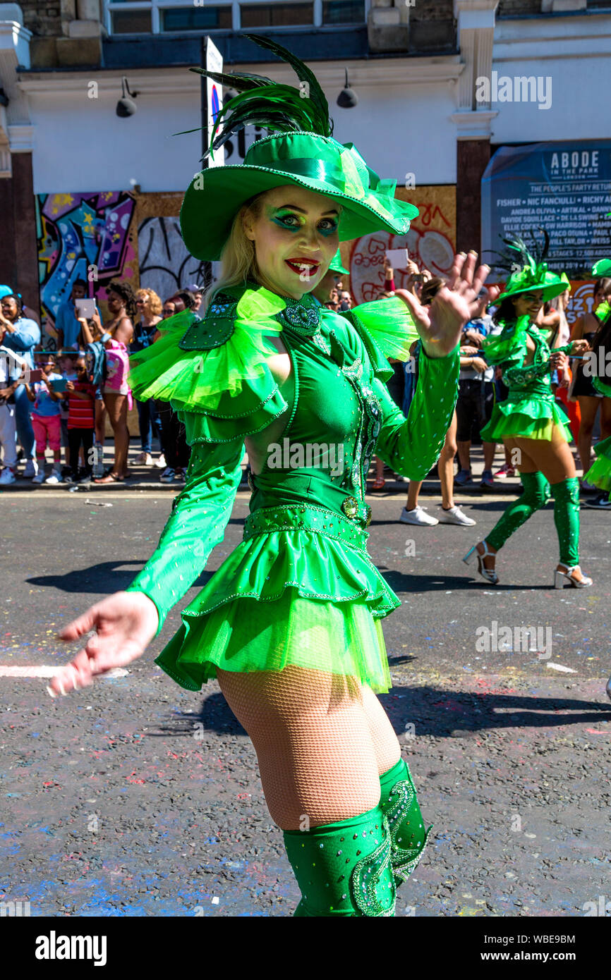 26 Agosto 2019 - Femmina ballerina vestito in un costume verde e il cappello con le piume al carnevale di Notting Hill su un caldo lunedì festivo, London, Regno Unito Foto Stock