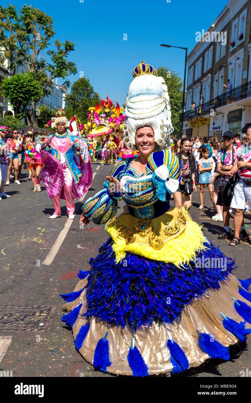 26 Agosto 2019 - La gente vestita in costume e parrucche in polvere in parata, carnevale di Notting Hill su un caldo lunedì festivo, London, Regno Unito Foto Stock