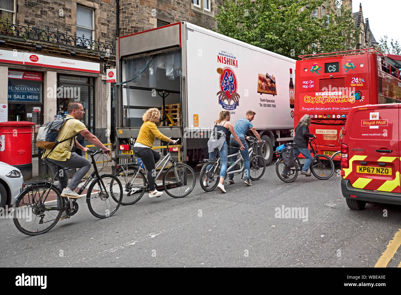 Un gruppo di ciclisti traffico di negoziazione in Forrest Road nella Cittã Vecchia di Edimburgo,. Foto Stock