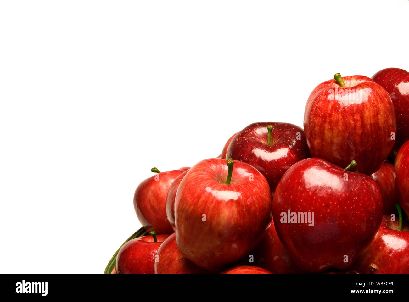Inquadratura orizzontale di un gruppo di brillanti le mele rosse nell'angolo inferiore destro dell'immagine. Sfondo bianco con copia spazio. Foto Stock