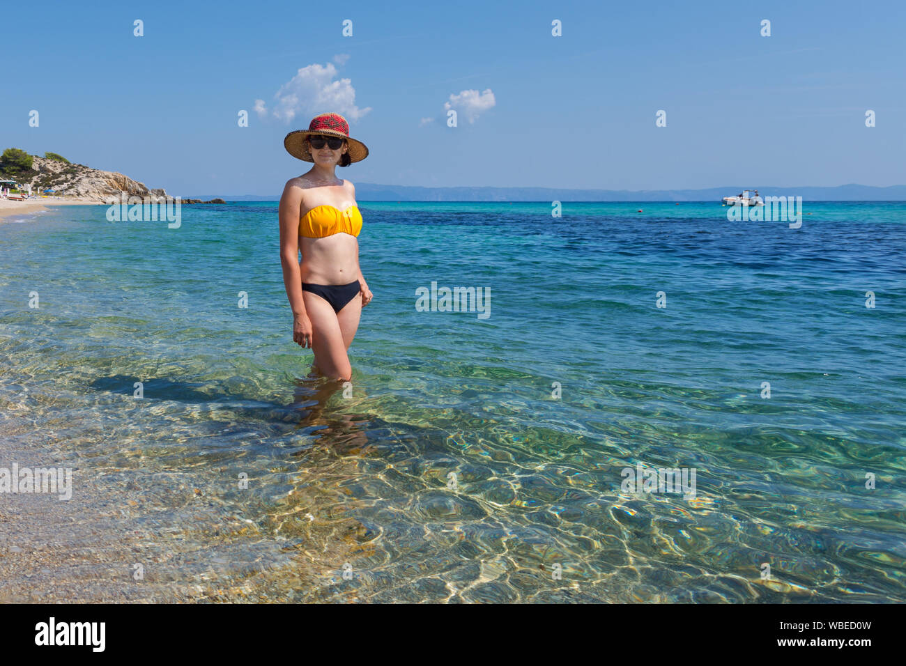 Moda giovane donna su Platanitsi esotica spiaggia di Sarti, Sithonia, Grecia con acqua cristallina e spettacolari forme delle rocce Foto Stock