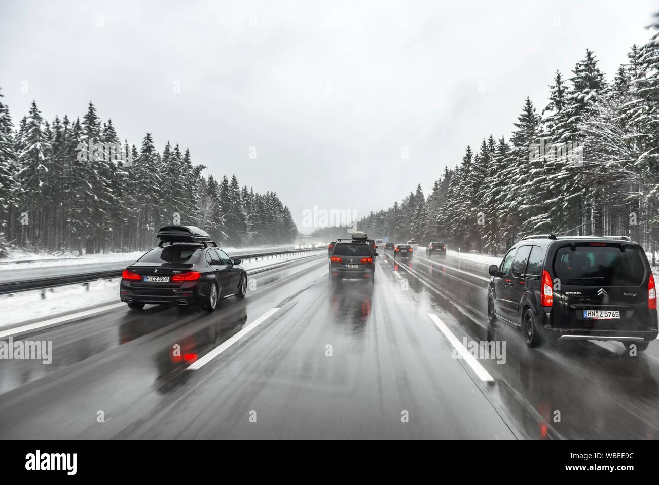 Cattive condizioni meteo, traffico automobilistico durante forti nevicate e pioggia sulla autostrada A8, vicino a Monaco di Baviera, Germania Foto Stock