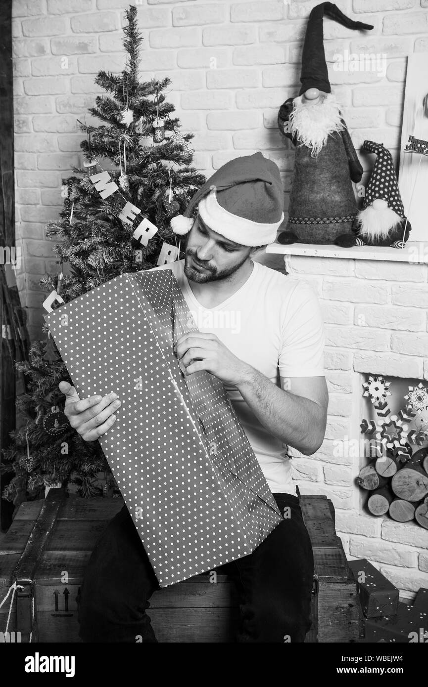 Online shopping di Natale. Anno nuovo scena con struttura ad albero e regali. consegna di regali di Natale. l uomo in santa hat tenere presente di natale. Felice santa l'uomo. La mattina prima di Natale. Divertimento natalizio Foto Stock