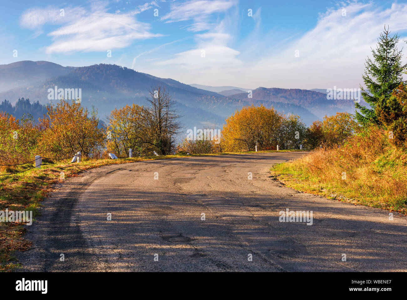 Vecchia strada a serpentina in montagna. bellissimo paesaggio autunnale mattinata nebbiosa luce. Splendido ottobre meteo con soffici nuvole del cielo. ridge in t Foto Stock