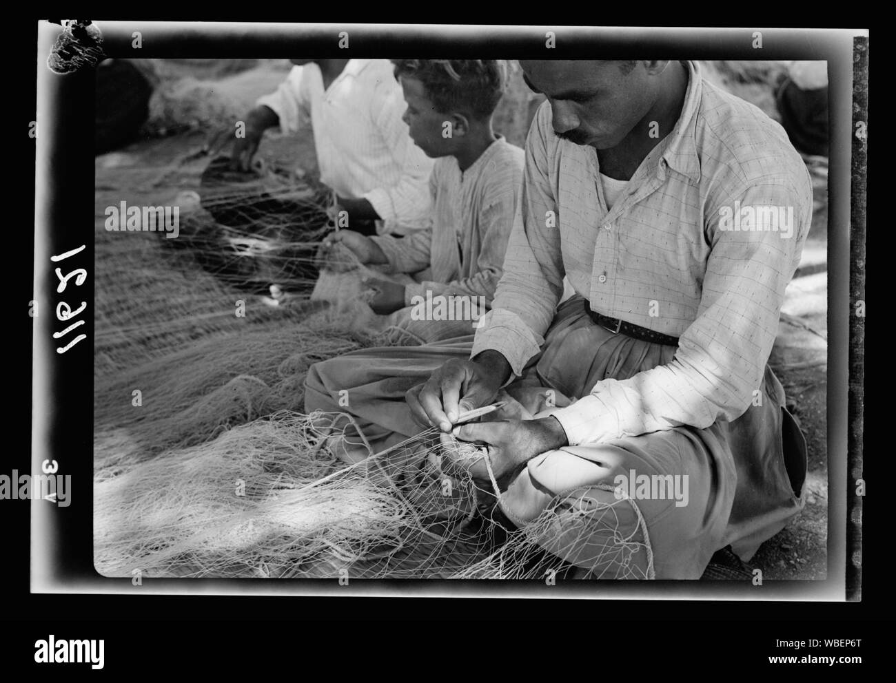 La Galilea viaggio. Tiberiade la pesca (arabo). Fisherman rammendo la sua rete, mostrando close up di ago usato Abstract/medio: G. Eric e Edith Matson Collezione fotografica Foto Stock